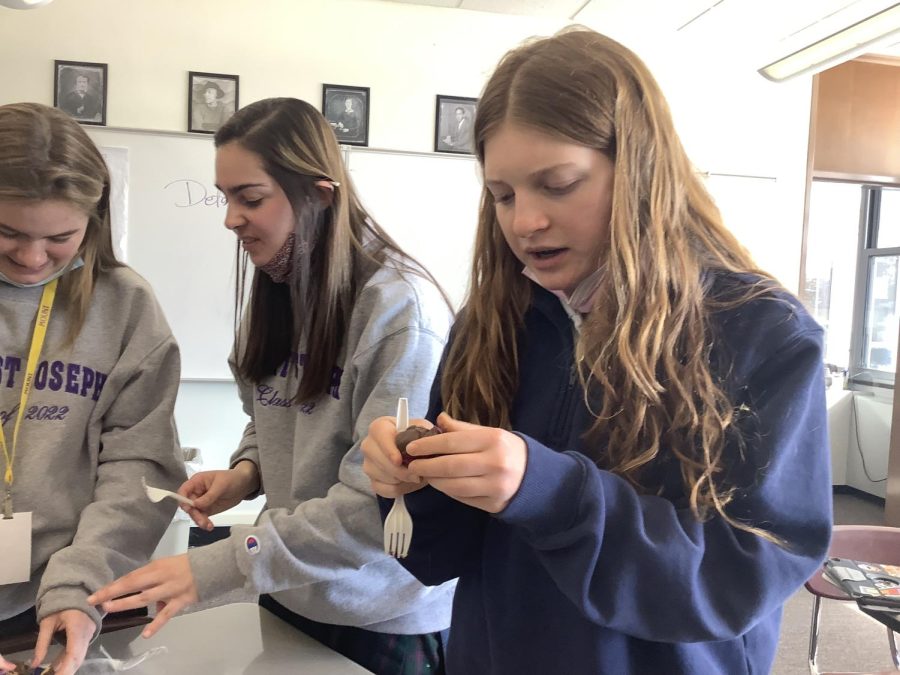Veronica Cherico ‘23 and Sophia Brigidi ‘22 taste test a chocolate truffle and several other chocolate desserts from Mount’s Valentine’s Day baking competition. The money from the competition is going towards Student Council. 