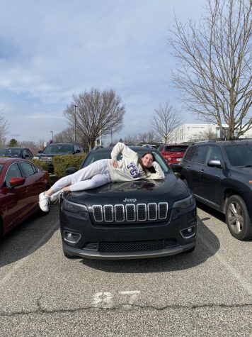 Meredith Taylor ‘22 lies horizontally on her black Jeep Grand Cherokee.