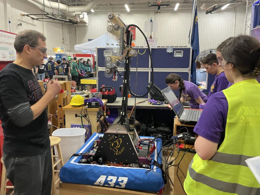 The robot has run into some unexpected issues on the battlefield. Programmers work hard to find Firetruck’s wounds. From left: Jason Soley ( Mentor); Emma Gibbons ‘23; Sarah ‘Sauce’ Rossman ( Mentor); Maureen Phelan ‘23; Reese Wills ‘23. 