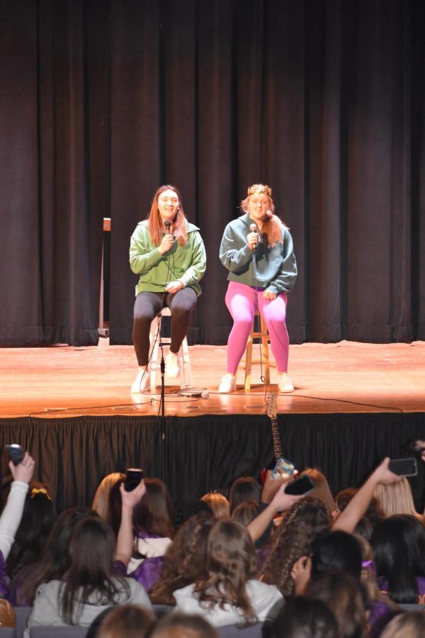 Alexa Konowal '23 and Nina Rowello '23 sing a heartfelt duet of "homecoming queen?" by Kelsea Ballerini during 2023 Charity Day. They passed a "homecoming crown" to each other as students waved their flashlights in the audience.