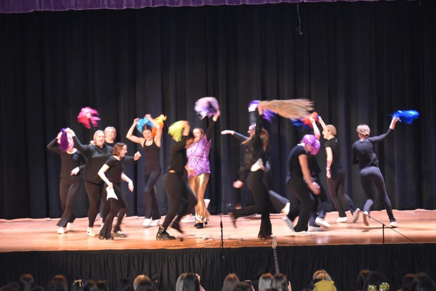 Señora Hoffman’s Honors Spanish IV class dances in a group circle during the instrumental ending of “Chiquitita” by ABBA. Leaving their single-filed line, they wave their colorful wigs through the air. 