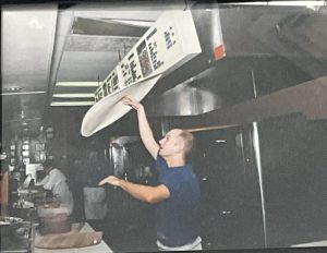 Mr. Boccella flips pizza dough in his Grandfather’s pizza shop.