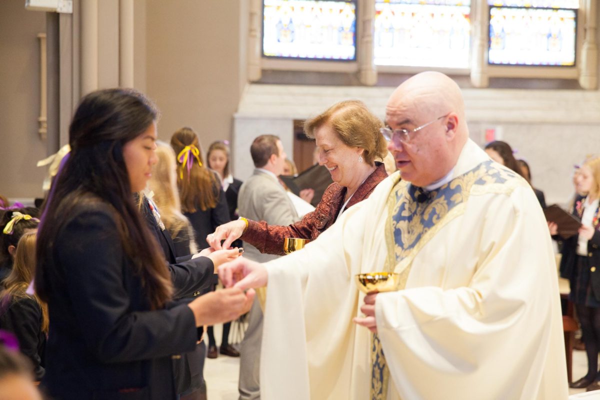 Sr. Mary Dacey distributing communion at Founders' Day mass in the Motherhouse.