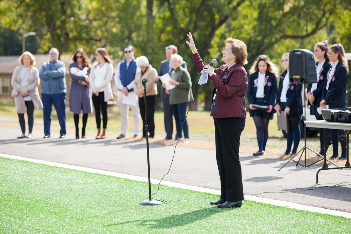 Sr. Mary Dacey gestures to the crowd as she dedicates the turf field to Sr. Kathleen Brabson. 