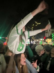 Riding on Sabrina Alcorn '25's  shoulders, Grace McCarthy ‘25 chants the Eagles’ song while celebrating at the Keswick in Glenside.