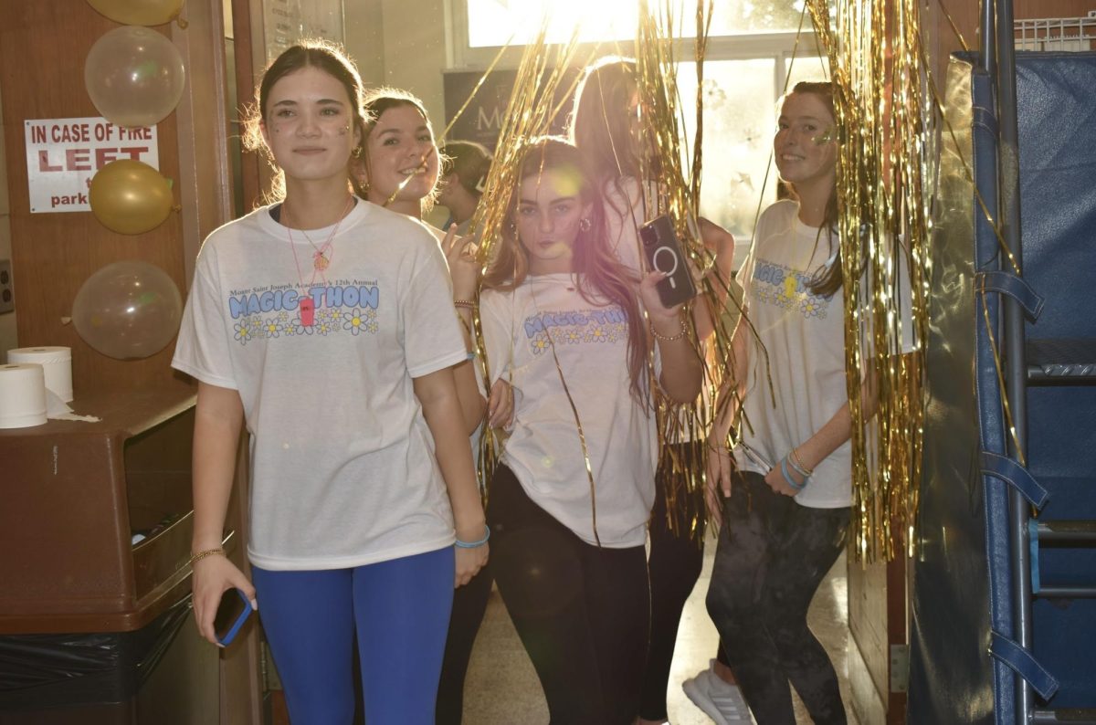 Walking through the golden streamers, from left freshman: Caycee Snyderman ‘28, Maura Mcllhenny ‘28, Quinn Jordan ‘28 enjoy their first THON. 
