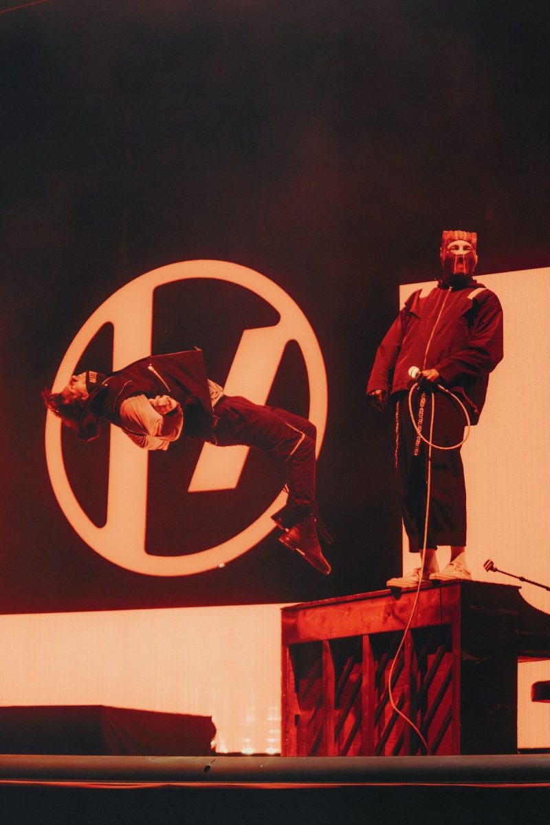 Joshua Dun (drummer) backflips off of the piano as Tyler Joseph (singer) performs the band’s song “Holding Onto You.”