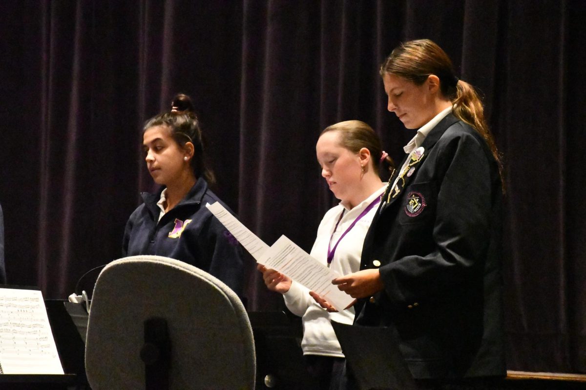 Junior Charli Schoen ‘27, a member of the liturgy team, reads about a saint during the All Saints’ Day prayer service on Nov. 1.
