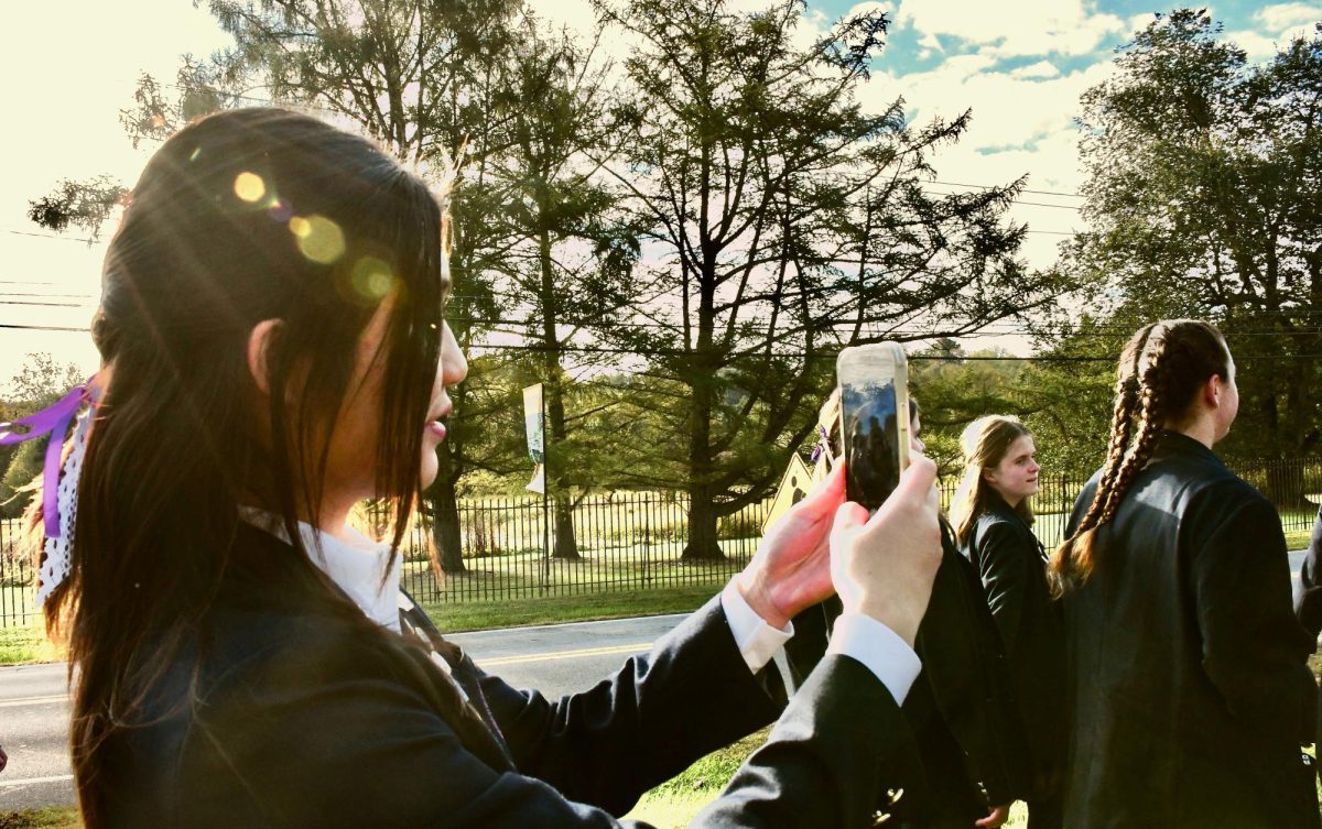 Emma Meng ‘26 takes photos of her friends and the scenery during the walk to morning Mass while Lexi Kelly ‘26 and Ava Smith ‘26 pose for a photo to commemorate the day. 

Many groups stopped along the way to have their photos taken and keep the memories of their last Founders’ Day wrapped in the love of their community. 

“I feel pretty sentimental about my last Founders’ Day, but I’m grateful for the people I’ve been able to spend it with and I’m really grateful for the opportunity to be a part of such a community.” Emma Meng ’26 said.
