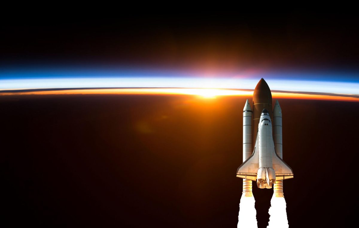 A spacecraft rises above Earth’s horizon at sunrise.
